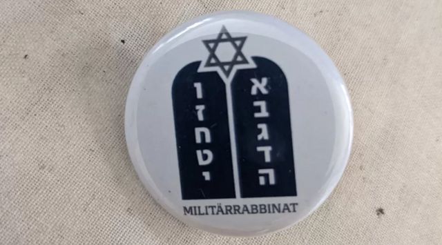 Um distintivo de capelania militar judaica moderna, com escrita em hebraico e alemão e a estrela de David no topo