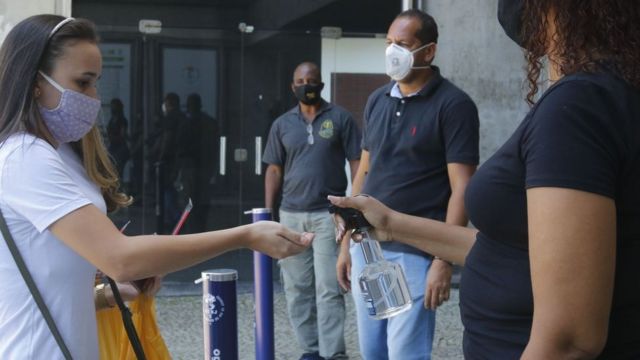 Jovem passa álcool gel antes de entrar na prova do Enem 2020