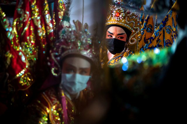 Members of a Chinese opera troupe prepare before performing at a shrine during the annual vegetarian festival in Bangkok, Thailand, 6 October 2021.