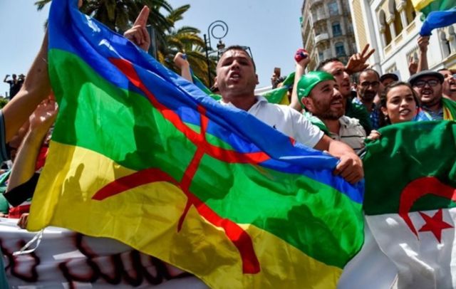 متظاهرون أمازيغ يرفعون العلم الأمازيغي خلال احتجاجهم في العاصمة الجزائرية