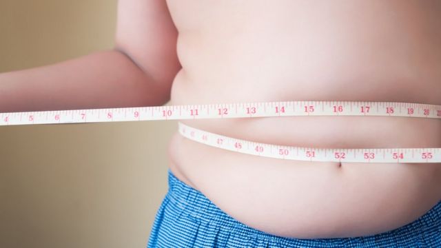 Persona midiéndose la cintura