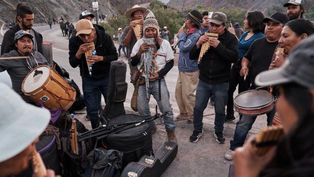 Manifestantes realizando atividades culturais com música tradicional