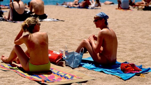 dve žene se sunčaju na plaži