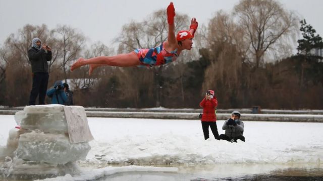 Una mujer fue fotografiada lanzándose desde un pedestal de hielo hacia un lago helado en Shenyang, China, en enero.