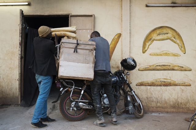 Alhassan Djitteye, who has been delivering bread for ten years, loads up his motorbike before heading out to make deliveries.