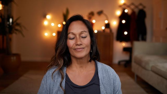 Mujer meditando con los ojos cerrados