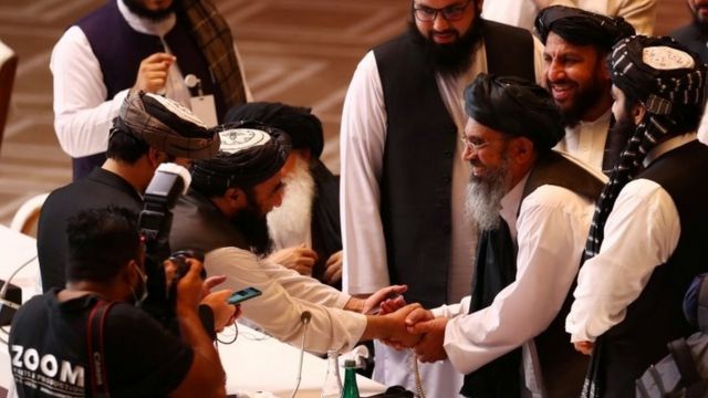 Los delegados talibanes estrechan manos en las negociaciones con el gobierno afgano en Doha, Qatar.