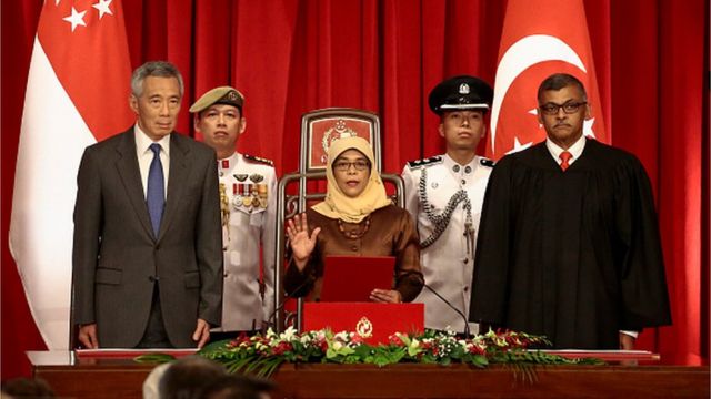President-elect Halimah Yacob (C) takes the oath of office while flanked by Singapore Prime Minister Lee Hsien Loong (L) and Chief Justice Sundaresh Menon (R) during the presidential inauguration ceremony at the Istana Presidential Palace in Singapore