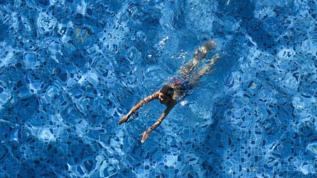 Un niño nada en una piscina