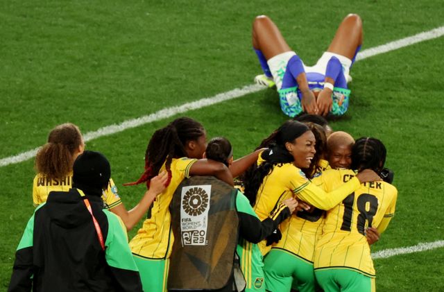 Jugadoras jamaiquinas celebran mientras las brasileñas sufren la eliminación.