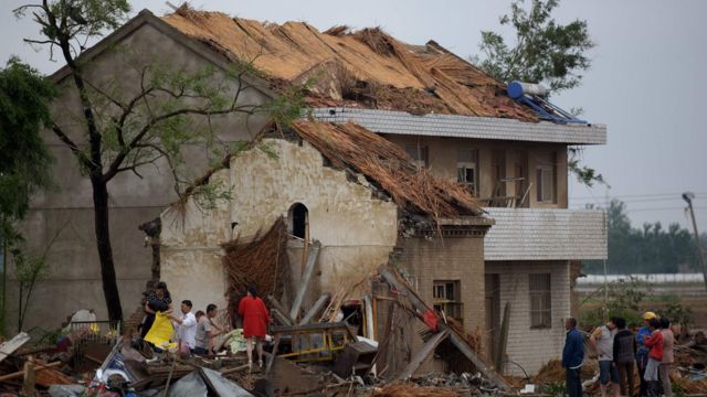 Pobladores caminan entre las ruinas de las casas que dejó el tornado en Funing, Yancheng, en la provincia de Jiangsu.