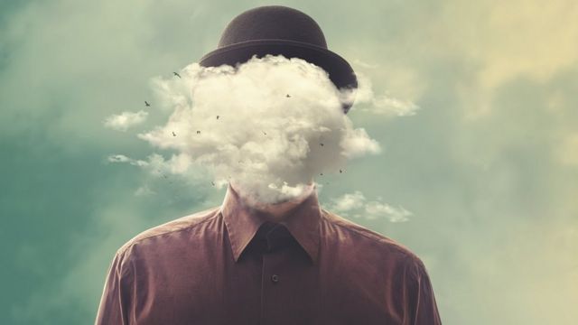 Montaje surrealista: un hombre con un sombrero caído y una nube en su cara.
