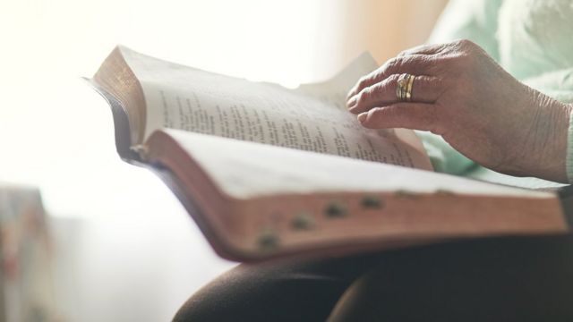 Una persona mayor lee la biblia