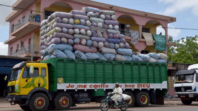 Ifoto yo kuwa gatandatu 4/06/ 2016 muri Bouake yerekana iKamyo iriko amajambo: "NIhaye Imana", yikoreye imizigo yerekeza Bamako, Mali. / AFP PHOTO / ISSOUF SANOGOISSOUF SANOGO/AFP/Getty Images