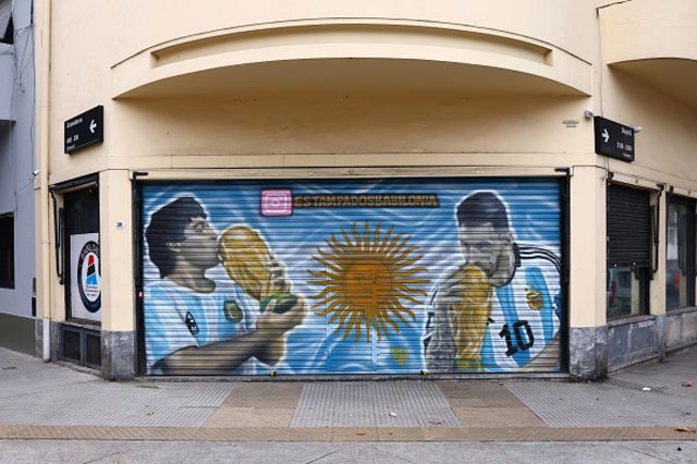 Grafite em portão com imagens de Maradona e Messi