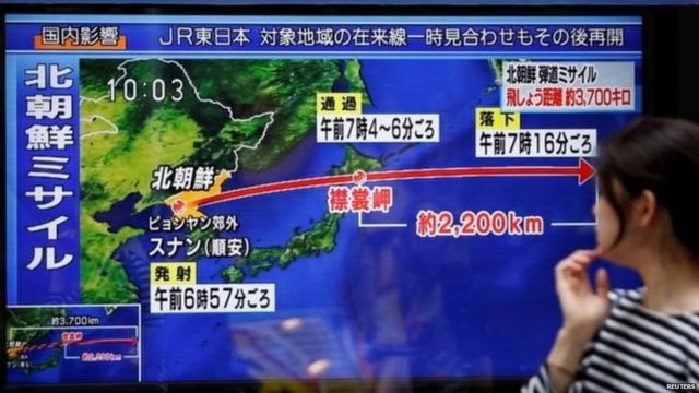 A passerby looks at a TV screen reporting news about North Korea's missile launch in Tokyo