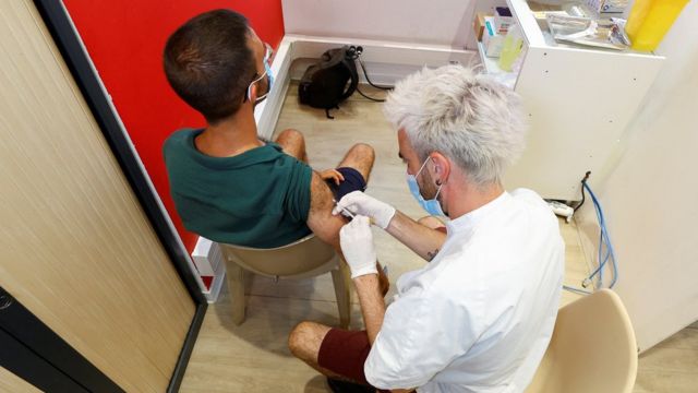 Profissional de saúde vacinando homem contra o monkeypox