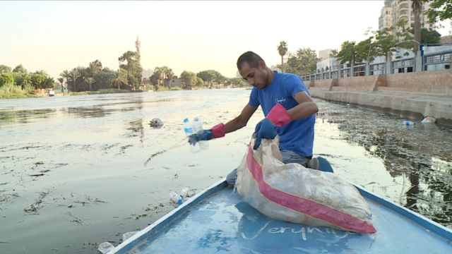 رجل في رحلة صيد مخلفات البلاستيك في نهر النيل