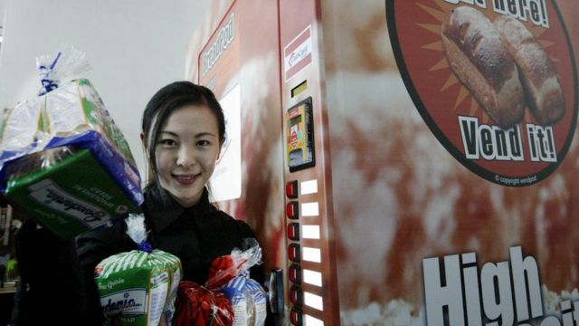 2004年3月25日，一位营销主管在展示新加坡自动售货机出售的一些面包。