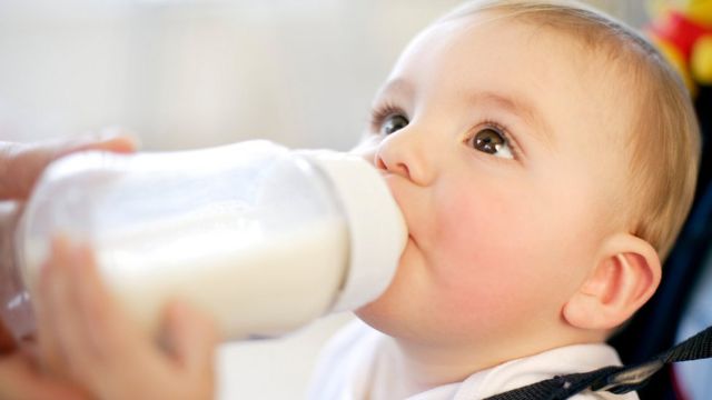 Nine month old boy drinking a bottle of milk