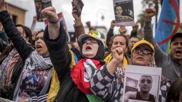 Moroccan protesters hold photos of detainees and shout slogans