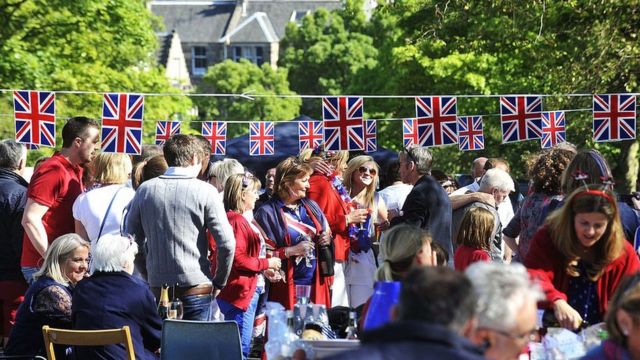 People gather in the street with flags to celebrate the Queen's Diamond Jubilee in Edinburgh on June 3, 2012