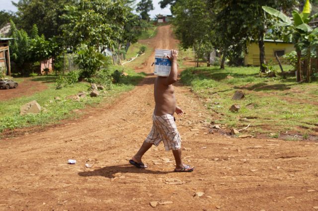 Hombre cargando con cubo de agua