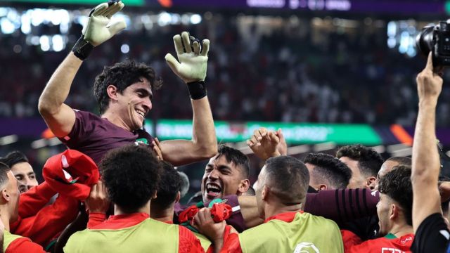 Moroccan goalkeeper Yassine Bounou is thrown into the air as Morocco celebrate their victory during the 2022 FIFA World Cup Qatar round of 16 match between Morocco and Spain