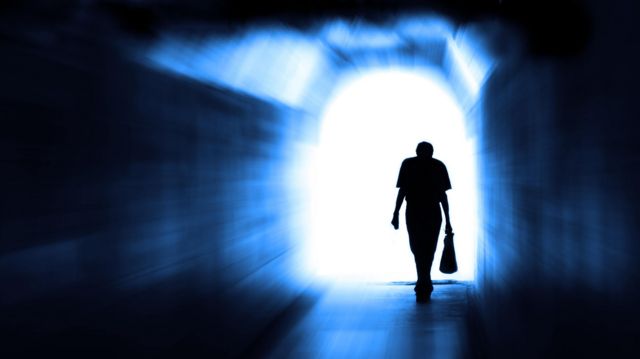 Un hombre caminando hacia la salida de un túnel