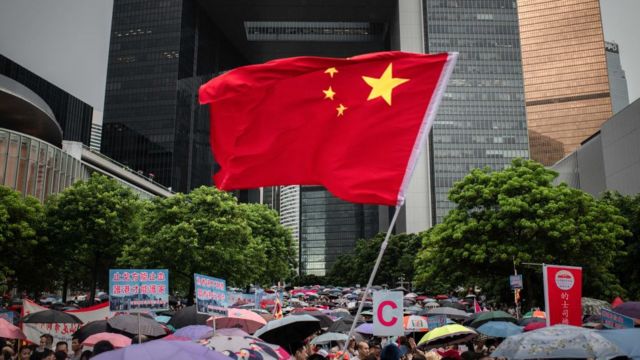 Una bandera china ondea entre un grupo de manifestantes pro gobierno en una manifestación en el parque Tamar, en Hong Kong