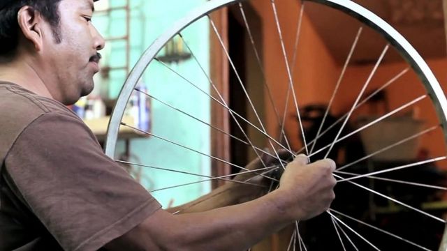 Guatemalan man making a bicycle machine from a second-hand bicycle