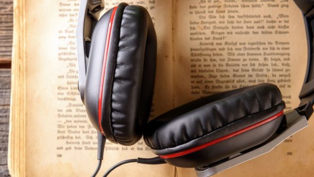 A pair of headphones resting on an open book