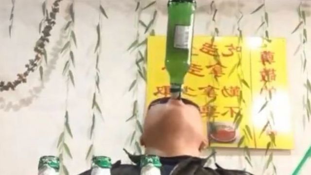 Liu Shichao bebendo no gargalo de garrafa