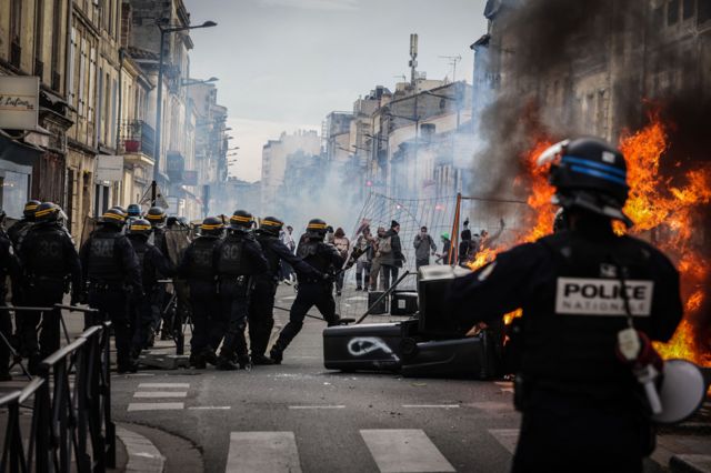 Protesters clash with riot police during a demonstration, a week after the government pushed a pensions reform through parliament without a vote, using the article 49.3 of the constitution, in Bordeaux, south western France, on March 23, 2023.