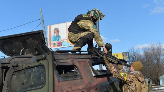 قوات أوكرانية تجمع بعض الأسلحة الروسية في خاركيف.