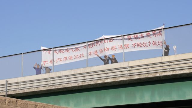 王涵和一些示威者洛在杉磯十號公路上的一座立交橋上舉起標語。