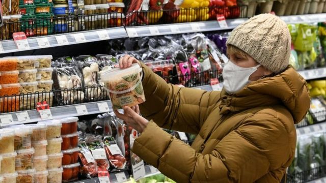 A woman looking at pickled foods in a supermarket in Russia