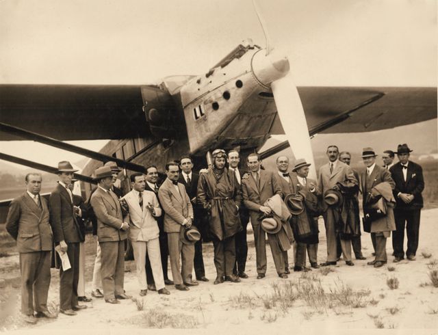 Saint-Exupéry ao lado de outras pessoas, em frente ao avião, no Rio de Janeiro, em 16 de abril de 1930