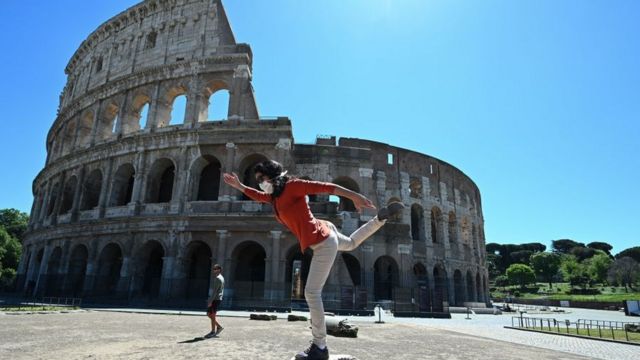 A woman exercises in front on the Coliseum in Rome
