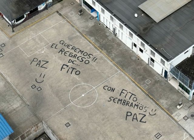 Vista aérea de um pátio de prisão, com inscrições pedindo o retorno de Fito