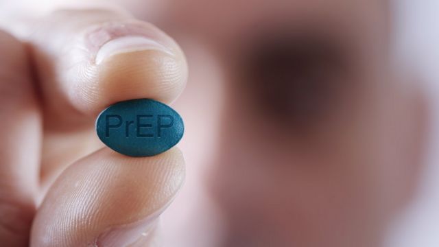 Uma pessoa segurando um comprimido PrEP contra HIV