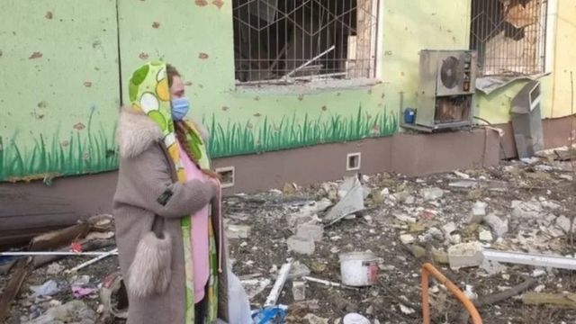 Mulher observa destroços deixados por ataque em maternidade em Mariupol