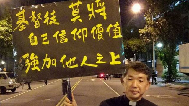 陳思豪牧師舉牌,上面寫到:基督徒莫將信仰價值強加他人之上