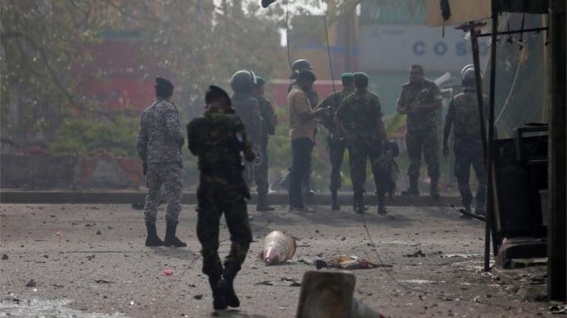 ဗုံးပေါက်ကွဲတဲ့နေရာကို စစ်ဆေးနေတဲ့ လုံခြုံရေး တပ်ဖွဲ့၀င်များ။