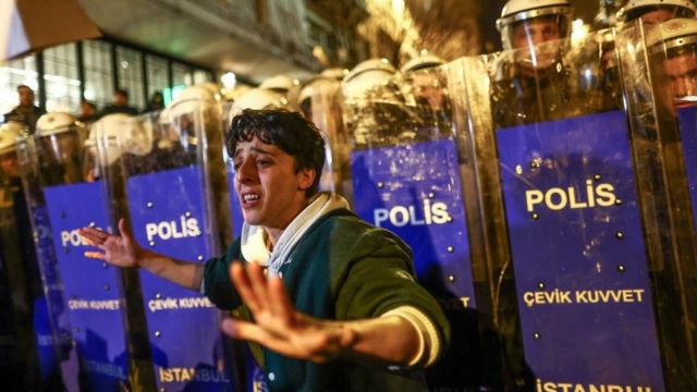 متظاهر يقف أمام شرطة مكافحة الشغب التركية