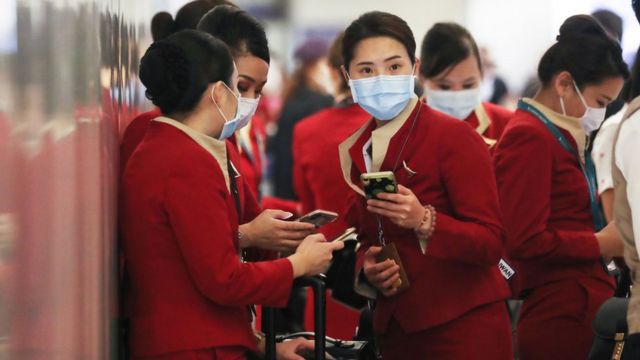 A group of Cathay Pacific flight attendants who have just arrived from Hong Kong at Los Angeles International Airport are talking (28/2/2020)