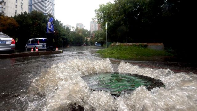 Вода, бурлящая у люка на московской улице