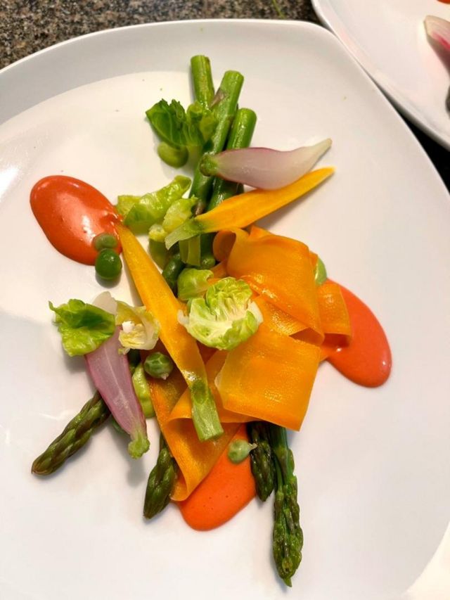 Un ragú de verduras con salsa holandesa de remolacha.