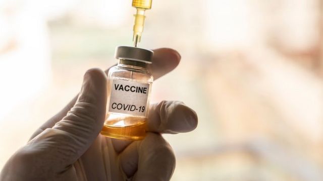 Fotografia de uma ampola com um rótulo escrito "Vacina covid-19" e uma seringa.