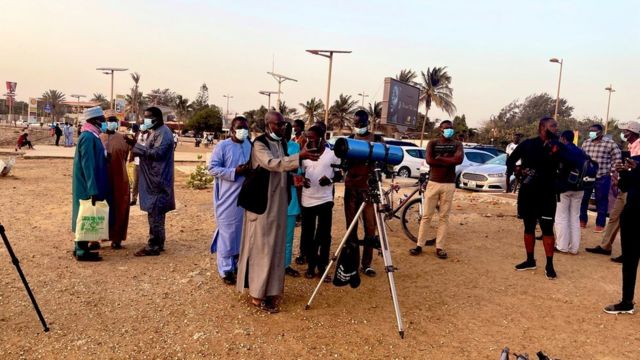 Des membres de l'Association sénégalaise d'astronomie en compagnie de religieux scrutent la lune mardi à Dakar